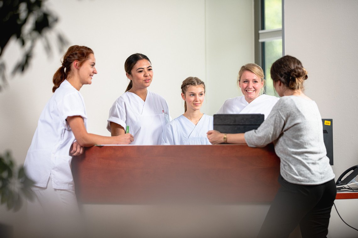 Auszubildende stehen um einen Service Desk 